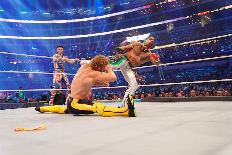 Logan Paul attempts to duck out of the way of Rey Mysterio.