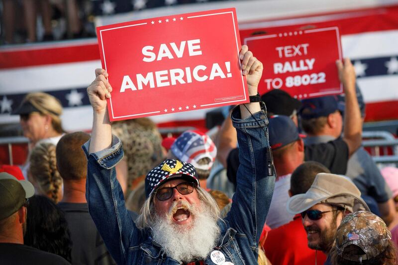 A man holds a ‘Save America’ sign, Donald Trump’s new rallying cry. AFP