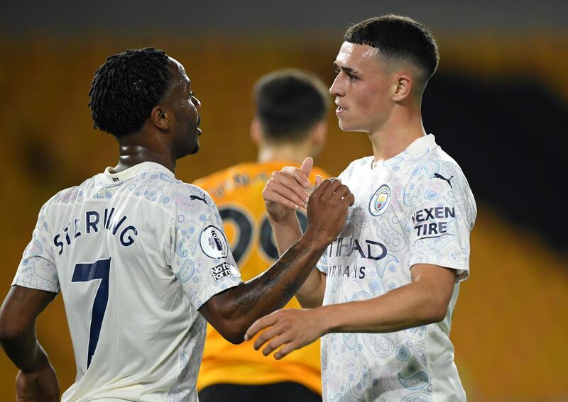 Manchester City's Phil Foden, right, is congratulated by teammate Raheem Sterling after scoring his team's second goal during the English Premier League soccer match between Wolverhampton Wanderers and Manchester City at Molineux Stadium in Wolverhampton, England, Monday, Sept. 21, 2020. (Stu Forster/Pool via AP)