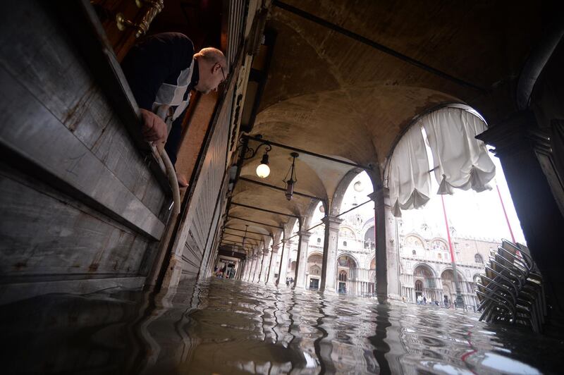 A man looks at floods in St. Mark square in Venice, in the morning of November 17, 2019 prior an "acqua alta", or high water, of 160 centimetres (over five feet) expected at midday.  Venice was braced on November 17 for an unprecedented third major flooding in less than a week, with sea water due to swamp the already devastated historic city where authorities have declared a state of emergency. / AFP / Filippo MONTEFORTE                  
