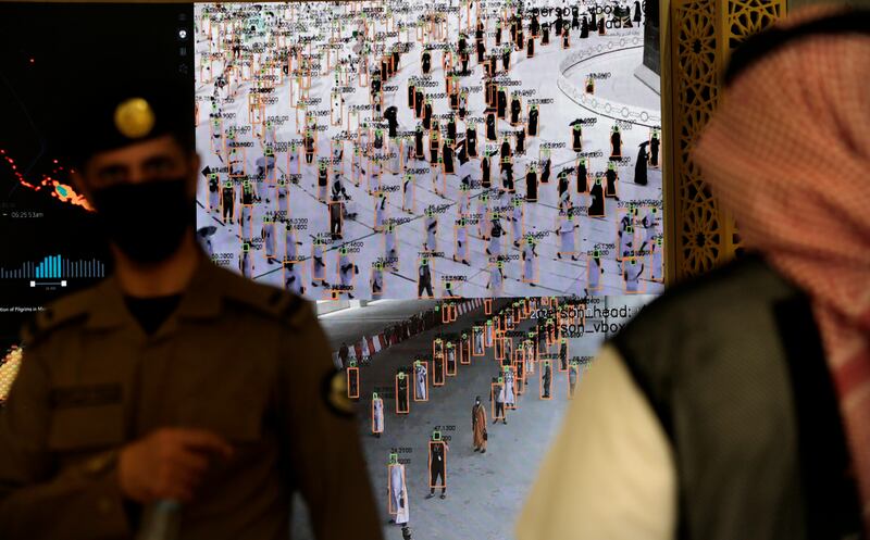 Saudi security staff watch smart screens, which identify passing pilgrim's authorisation to participate in Hajj, at al Zaidy reception centre in Mecca.