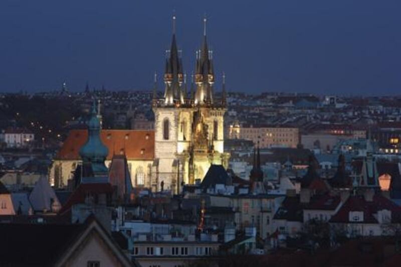 The Gothic Tyn Church in Old Town Square is illuminated at night. Old Town, one of Prague's most charming quarters, is full of historic buildings in various architectural styles.