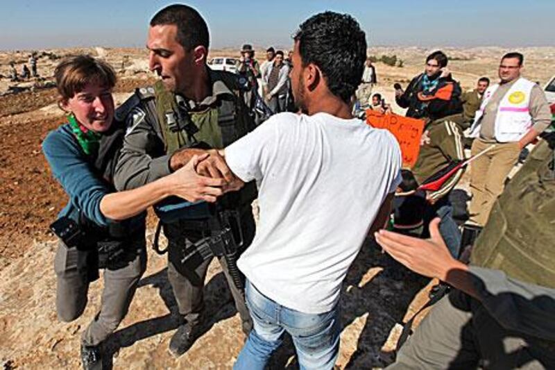 Israeli soldiers arrest a Palestinian demonstrator at the Jewish settlement of Sosia near the village of Yatta, south of the West Bank city of Hebron, on Saturday.