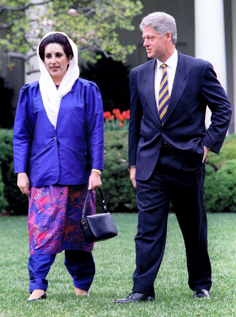 President Clinton (R) and visiting Pakistani Prime Minister Benazir Bhutto walk through the Rose Garden on their way to lunch April 11 at the White House. Earlier, Clinton met with Bhutto in a bid to solve a dispute over $1.4 billion in military hardware, including F 16 jets