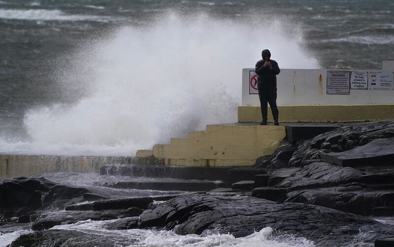A man takes photos of the waves at Blackrock Diving Board, Salthill, County Galway, Northern Ireland. PA
