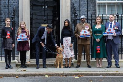 31/10/2022. London, United Kingdom. The Prime Minister Rishi Sunak and his wife Akshata Murty buy poppies, and a special 'poppy' dog collar for their pet Labrador Nova, from representatives of the Royal British Legion outside 10 Downing Street. Picture by Simon Walker / No 10 Downing Street