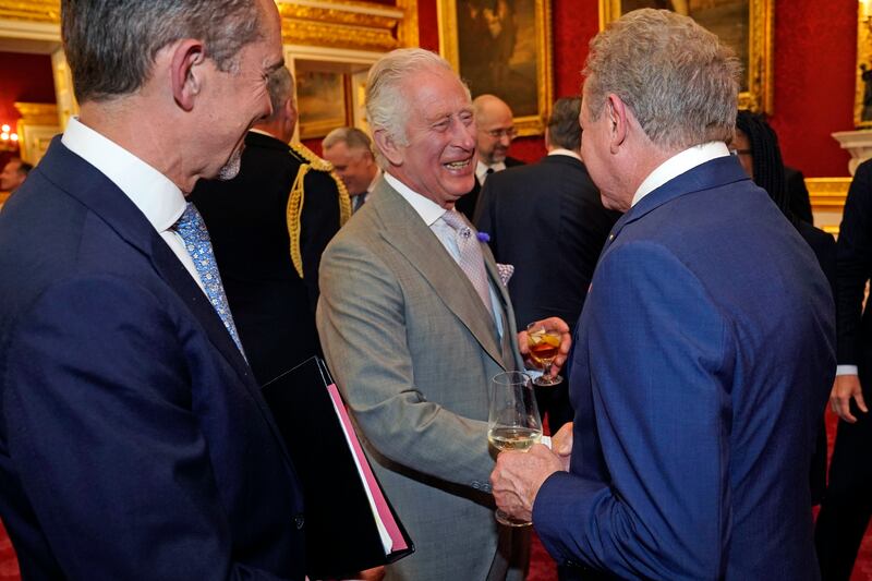 King Charles speaks with people attending the reception. PA