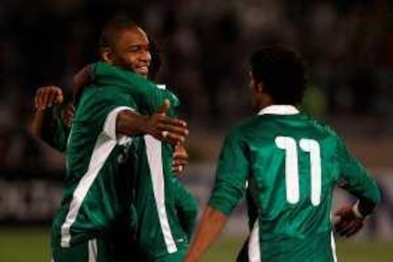 Saudi Redha Takar (L) extends his hand to teammate Naif Hazazi (R) as they celebrate after beating Iran in their Asian zone group B World Cup 2010 qualifying football match in Tehran on March 28, 2009. Saudi Arabia won the match, attended by Iranian president Mahmoud Ahmadinejad, 2-1. AFP PHOTO/BEHROUZ MEHRI