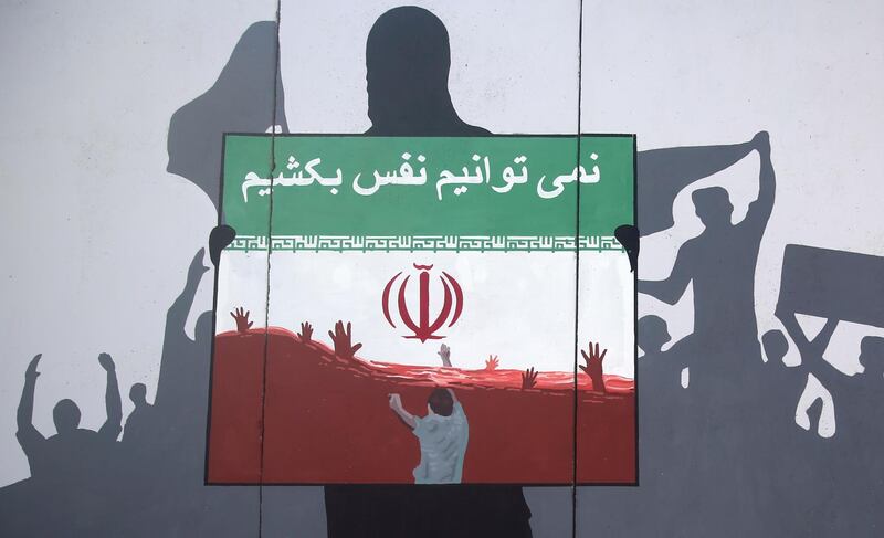 A view of a painting on a wall written in the Dari Language reading "We cannot breath" during a protest denouncing the killings of Afghan refugees in Iran in Kabul, Afghanistan, Monday, June 15, 2020. The violent deaths of Afghan refugees inside Iran has sparked an uproar despite denials from Tehran. (AP Photo/ Rahmat Gul)