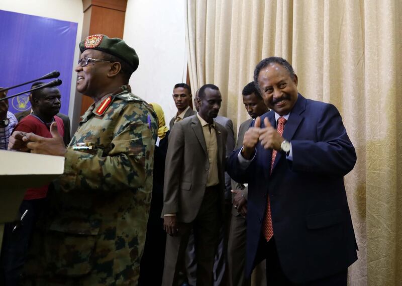 Sudan's new Prime Minister Abdalla Hamdok gives thumbs up as the presidential palace spokesman presents him to the media for a press conference following his swearing in at the presidential palace in Khartoum, Sudan. EPA