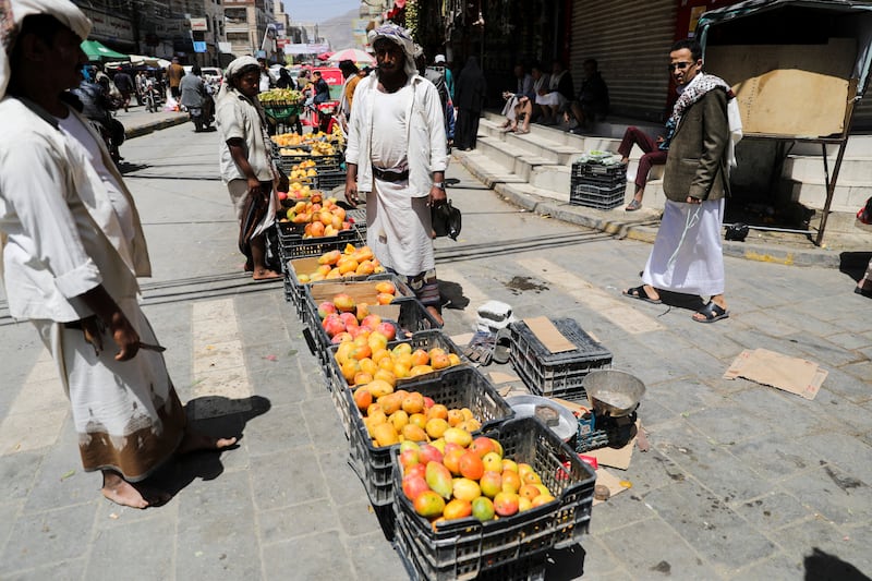 Vendors selling mangoes wait for customers.
