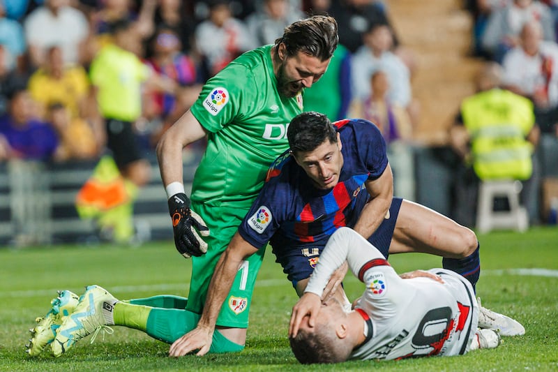 Rayo goalkeeper Stole Dimitrievski, left, reacts after Barcelona's Robert Lewandowski, centre and Rayo's Ivan Balliu clashed. AP Photo