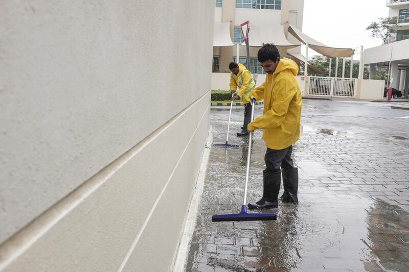 Maintenaince staff sweep water away after overnight rainfall in the Greens. Antonie Robertson / The National