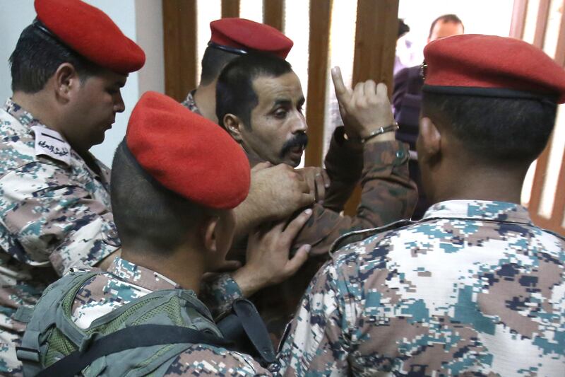 Maarik Al-Tawaiha (C) is led out of court following his trial, for the killing of three American military trainers outside an army base last year, on July 17, 2017, in the Jordanian capital Amman.
The military court in Amman found 39-year-old Tawaiha guilty of shooting the trainers as they waited to enter the King Faisal base at Al-Jafr in southern Jordan on November 4. 
 / AFP PHOTO / KHALIL MAZRAAWI