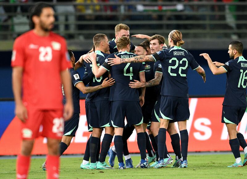 Australian players celebrate after scoring the opening goal against Palestine. EPA