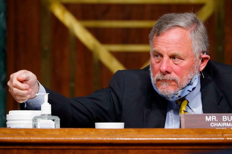 (FILES) In this file photo taken on May 5, 2020, Chairman Richard Burr, Republican of North Carolina, reaches for hand sanitizer at a Senate Intelligence Committee nomination hearing on Capitol Hill in Washington, DC. The FBI has seized a cellphone of US Senator Richard Burr to see if he used his insider access to classified intelligence to sell stock before the coronavirus pandemic struck, according to news reports on May 14, 2020. The Los Angeles Times said federal agents wielding a warrant seized the cellphone of the Republican Senate Intelligence Committee chairman late Wednesday at his Washington home. / AFP / POOL / Andrew HARNIK
