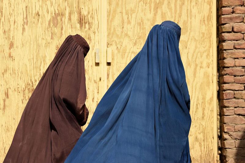 Afghan women wearing burqas from a polio immunisation team walk together during a vaccination campaign in Kandahar.  AFP