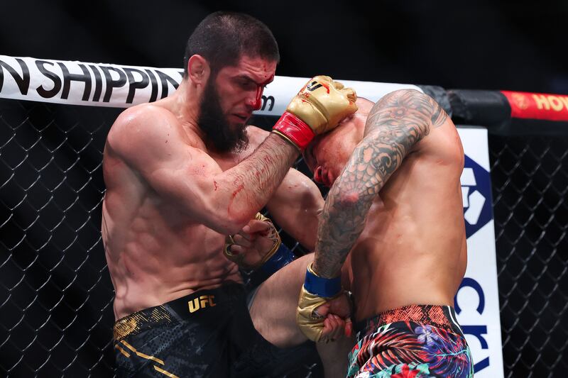 Dustin Poirier and Islam Makhachev exchange strikes in their lightweight title bout during UFC 302. AFP