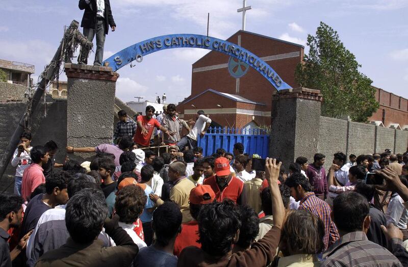 Pakistani Christians and rescue workers gather outside a church damaged from a suicide bomb attack in Lahore, Pakistan on March 15, 2015. KM Chaudary/AP Photo