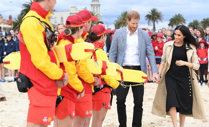 Harry and Meghan meet life guards on the beach. EPA