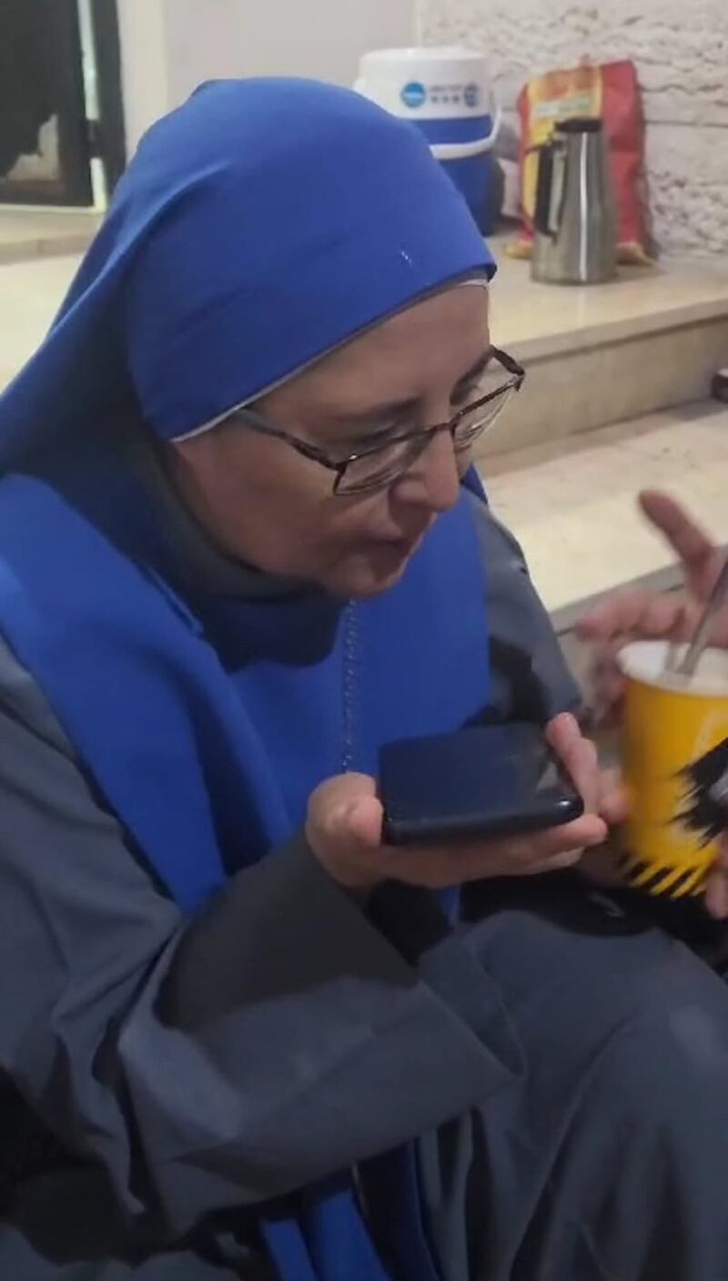A nun listens to daily calls from Pope Francis played out on a phone speaker in the Gaza church