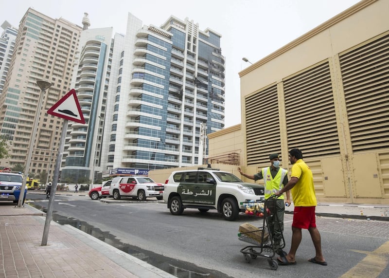 DUBAI, UNITED ARAB EMIRATES 13 MAY 2018 -A residence giving food to the a civil defence officer during the aftermath of the fire in Zen Tower in Marina, Dubai. Leslie Pableo for The National
