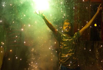 A Bharatiya Janata Party (BJP) supporter celebrates at the party office in Gauhati, India, Thursday, May 23, 2019. Indian Prime Minister Narendra Modi's party claimed it had won reelection with a commanding lead in Thursday's vote count, while the stock market soared in anticipation of another five-year term for the pro-business Hindu nationalist leader. (AP Photo/Anupam Nath)