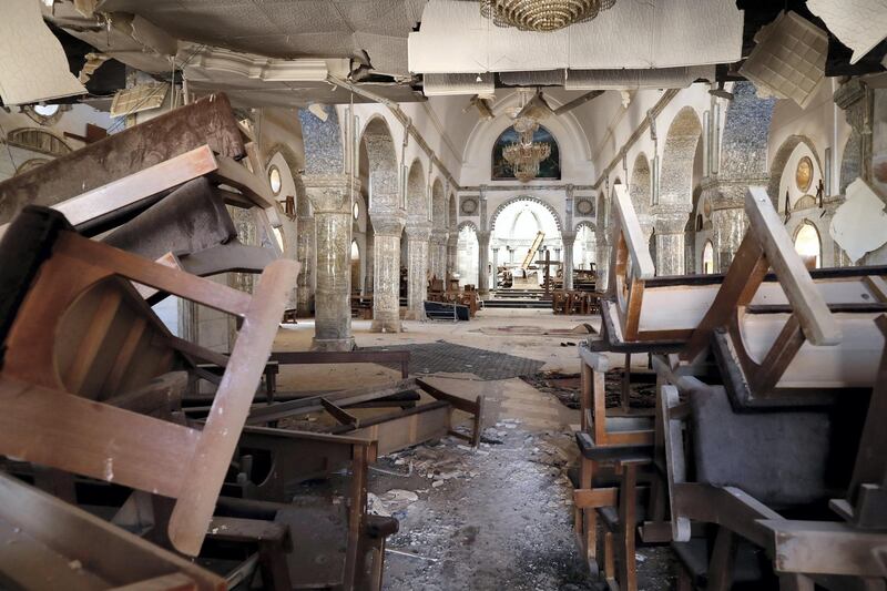 Destroyed furniture litter the ground of the heavily damaged Saint John the Baptist church in the Christian town of Qaraqosh, also know as Hamdaniya, some 30 kms east of Mosul, on December 4, 2016, one month after Iraqi forces recaptured it from Islamic State (IS) group jihadists. (Photo by THOMAS COEX / AFP)
