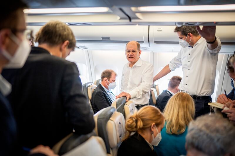 Olaf Scholz (C) on board a government plane after departing from Berlin's main airport. AP