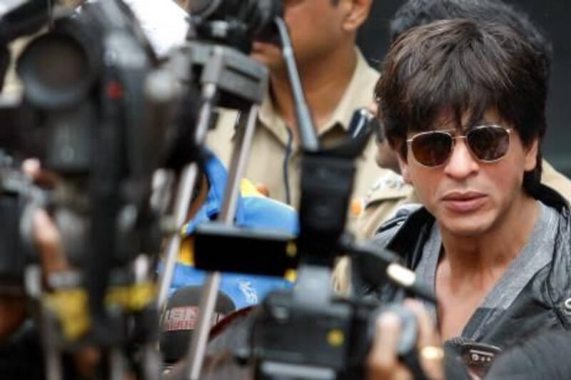 Bollywood actor Shah Rukh Khan speaks with the media after arriving at the international airport in Mumbai February 6, 2010. Bollywood is jittery over the fate of "My Name Is Khan", one of its biggest films of the year, with lead actor Shah Rukh Khan facing the ire of the Shiv Sena. The hardline Hindu group has threatened to disrupt Mumbai screenings of the film, which will be released February 12, if Khan does not apologise for backing the participation of Pakistani cricketers in the Indian Premier League. REUTERS/Punit Paranjpe (INDIA - Tags: ENTERTAINMENT POLITICS SOCIETY) *** Local Caption ***  DEL14_BOLLYWOOD-_0206_11.JPG