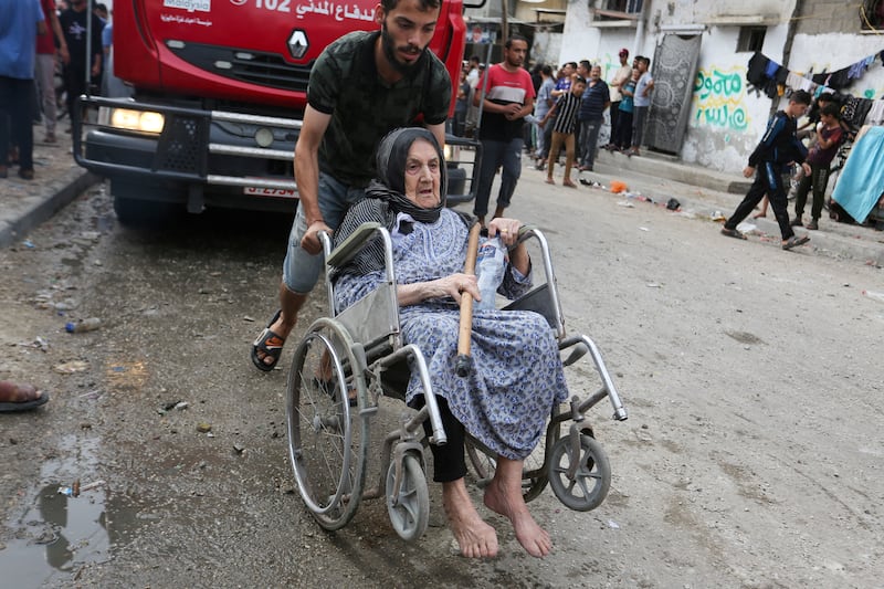 A Palestinian woman is evacuated at the site of an Israeli strike on a house, in Rafah. Reuters