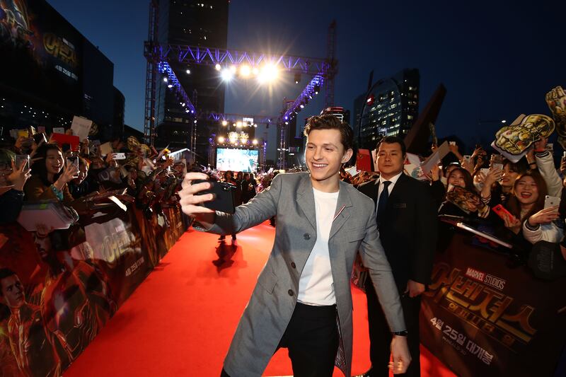 Tom Holland, in grey coat and black trousers, attends the Seoul 'Avengers Infinity War' premiere on April 12, 2018. Getty Images