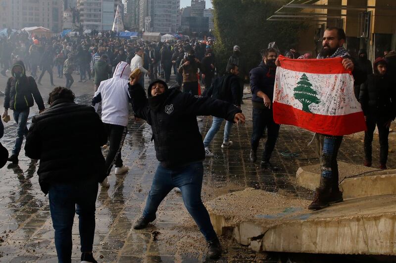 Anti-government demonstrators throw stones towards riot police. AP Photo