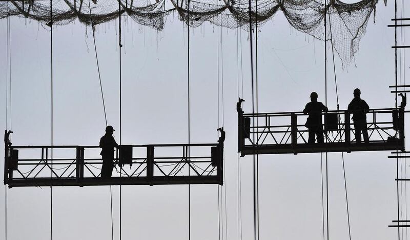 Labourers work on lifts at a construction site of a new railway station in Anhui province in China. Activity at mainland factories rose marginally in April but export orders fell sharply. Reuters