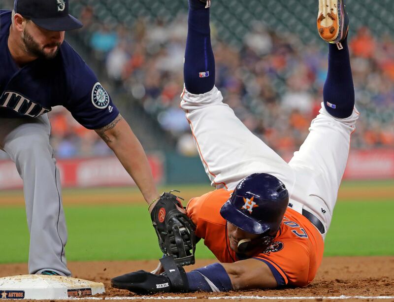 Houston Astros' Carlos Correa is tagged out by Seattle Mariners first baseman Yonder Alonso on a pickoff play during the third inning of a baseball game. David J. Phillip / AP Photo.