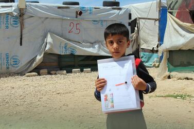 A pupil holds up his work pack for the week in the Bekaa Valley, Lebanon, where the Hands Up Foundation supports a school for 300 Syrian refugee children. Since March 2020, staff have developed a distance education initiative so that learning can continue in spite of the lockdown required because of Covid-19. Courtesy Hands Up Foundation