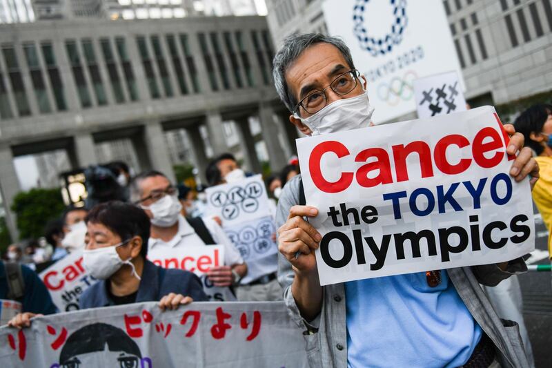 Demonstrators hold placards in front of the Tokyo Metropolitan government building during an anti-Olympic protest in Tokyo, Japan, on Wednesday, June 23, 2021. More evidence emerged that the Japanese publics opposition to next months Tokyo Olympics is losing steam, according to a series of media polls published roughly one month before the opening ceremony. Photographer: Noriko Hayashi/Bloomberg