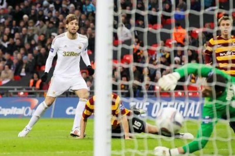 Swansea City's Miguel Michu, left, scores past Bradford City's goalkeeper Matt Duke, right, during the Capital One Cup Final at Wembley Stadium on Sunday. Sang Tan / AP Photo