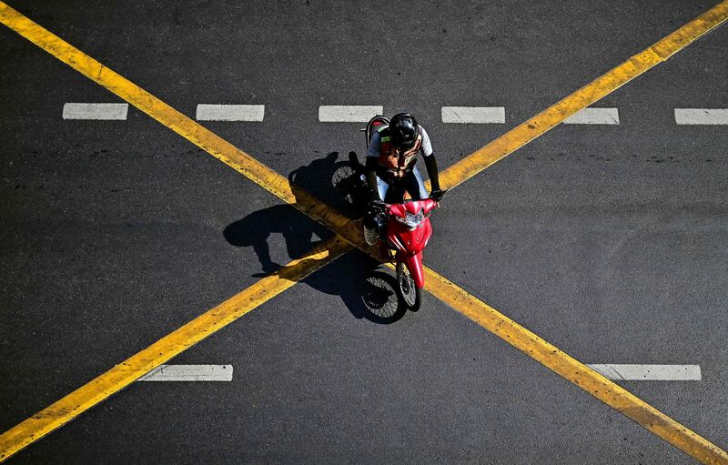 A motorcyclist crosses a road in Bangkok. AFP