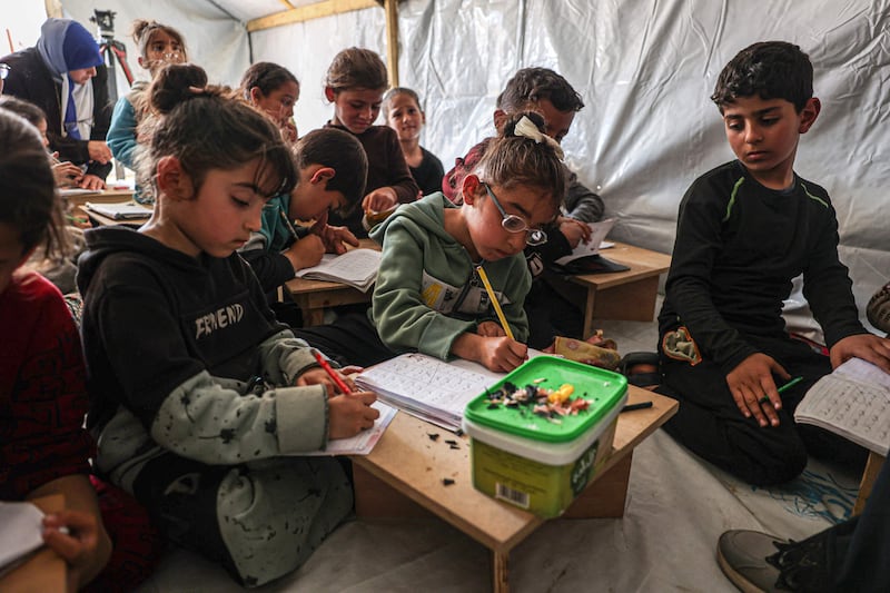 Children attend a lesson at a makeshift classroom in a camp for displaced Palestinians in Rafah, in the southern Gaza Strip. AFP