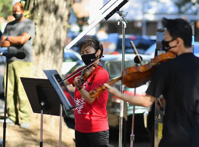 Violinist Quan Ge (L) and violist Cong Wu of the New York Philharmonic play with their 'bandwagon's pop-up concert series' at Betty Carter Park. AFP