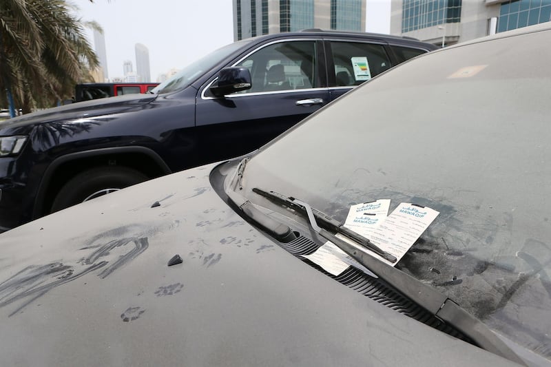 ABU DHABI , UNITED ARAB EMIRATES , JULY 24 – 2017 :- Dirty car with the fine ticket parked in the parking area near the corniche in Abu Dhabi . ( Pawan Singh / The National ) Story by Haneen