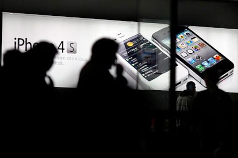 Customers wait in line prior to the initial sales of the new iPhone 4S at Apple's retail store in downtown Shanghai in this January 13, 2012 file photo. Apple Inc's next-generation iPhone has not even been released yet, but opportunistic sellers on China's largest e-commerce platform, Taobao, are already accepting pre-orders, complete with mock-up pictures and purported technical specifications. The hotly anticipated iPhone 5 is widely expected to be released sometime between August and October this year, although Apple itself has been tight-lipped about it. REUTERS/Carlos Barria/Files    (CHINA - Tags: BUSINESS SCIENCE TECHNOLOGY) *** Local Caption ***  SIN65_APPLE-IPHONE5_0712_11.JPG