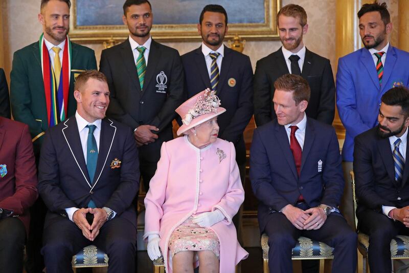 The Queen shares a word with England captain Eoin Morgan as they sit in preparation for a group fixture. AFP
