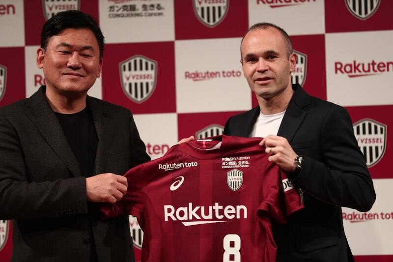 Spanish football star Andres Iniesta (R) and Hiroshi Mikitani, owner of Rakuten and Vissel Kobe club, hold the team's jersey during a press conference in Tokyo on May 24, 2018.  / AFP / Behrouz MEHRI
