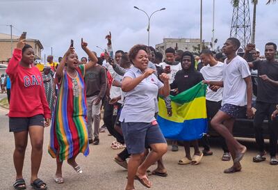People display the national flag as they celebrate in the streets of Akanda, Gabon, on Wednesday. EPA