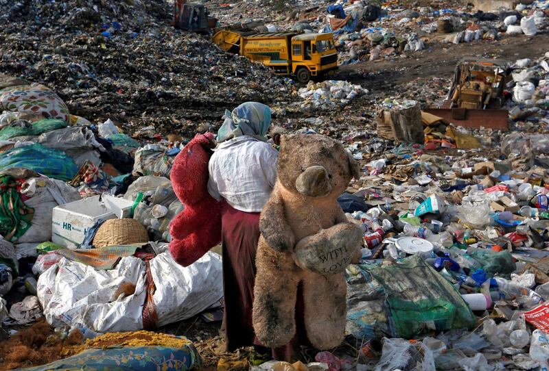 A woman carries stuffed toys through a dump site on the outskirts of Mumbai, India. Francis Mascarenhas / Reuters