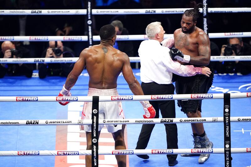 Referee Marcus McDonnell, centre, speaks to Jermaine Franklin, right, during a heavyweight boxing match against Anthony Joshua. AP