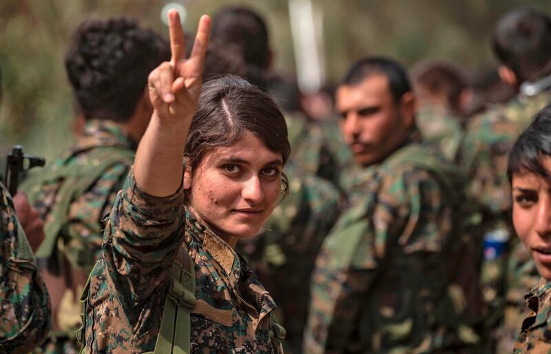 A female fighter of the US-backed Kurdish-led Syrian Democratic Forces (SDF) flashes the victory gesture while celebrating near the Omar oil field in the eastern Syrian Deir Ezzor province after announcing the total elimination of ISIS.  AFP