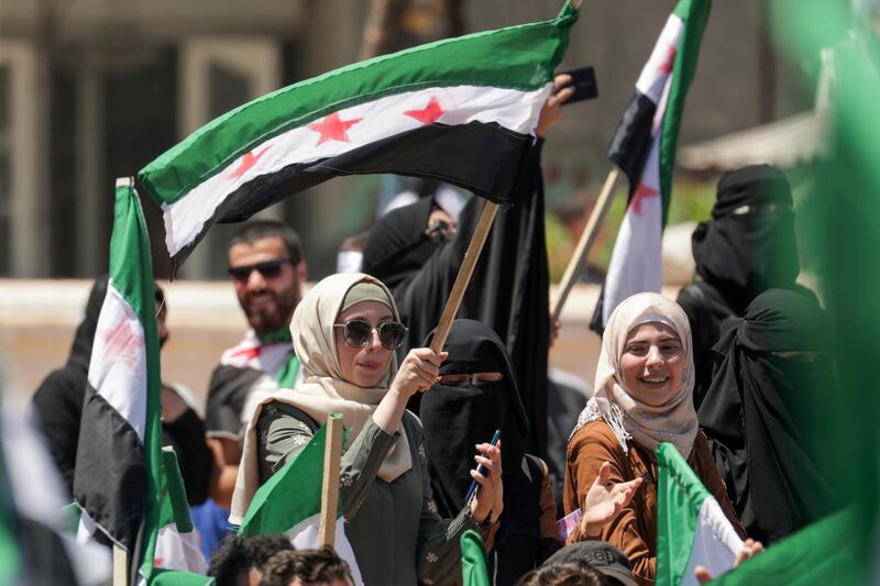 A woman holds an opposition flag during a demonstration against Syria's President Bashar Al Assad and presidential elections, in the opposition-held Idlib. Reuters